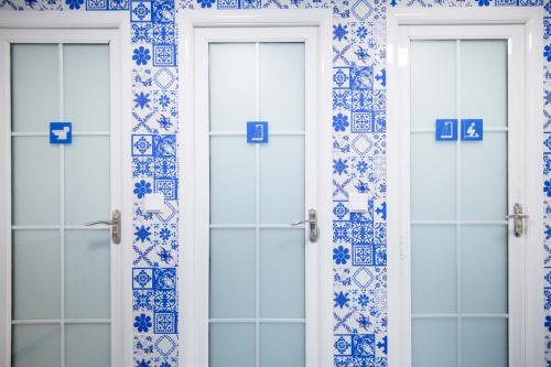 two doors in a bathroom with blue and white tiles at 弱水咖啡国际青旅 Only Cafe and Backpacker in Chongqing