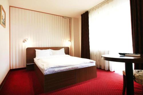 a hotel room with a bed and a table at Casa Boca in Cluj-Napoca