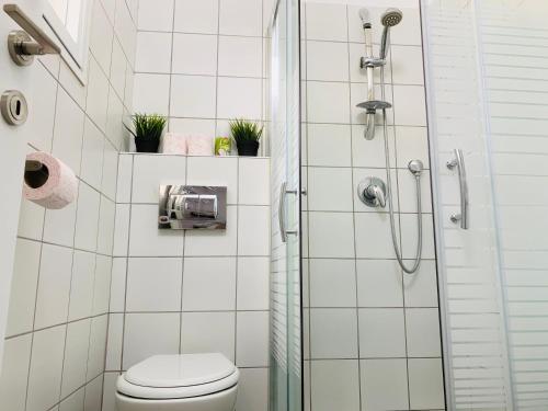 a white bathroom with a shower and a toilet at Mor's Place in Beer Sheva