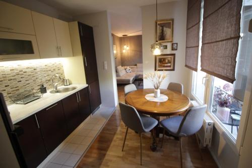 a kitchen and dining room with a wooden table and chairs at Nordlys in Tuzla