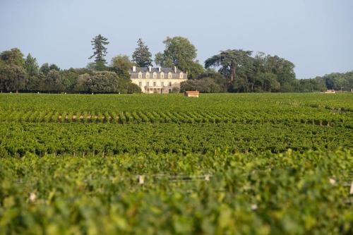 a large house in the middle of a field at La Maison d'Estournel in Saint-Estèphe