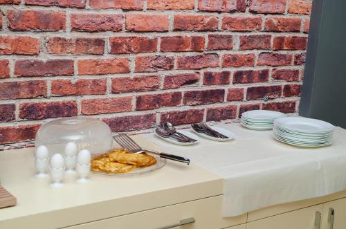 a table with a plate of food and a brick wall at Hotel EDEA in Korçë