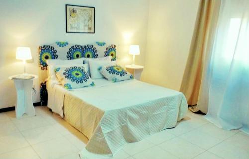 a bedroom with a bed with blue and white pillows at Trapani Egadistar Apartments in Trapani