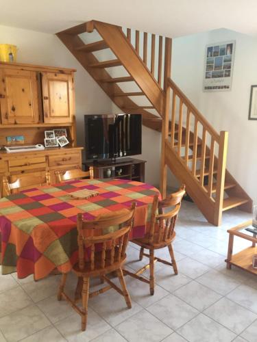 une cuisine avec une table et des chaises ainsi qu'un escalier dans l'établissement Voltaire, à La Turballe