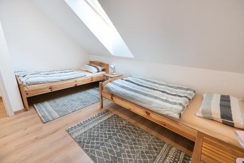 Cette chambre mansardée comprend 2 lits et un tapis. dans l'établissement APARTMENT ZYNGA - STUD FARM, à Šentvid pri Stični