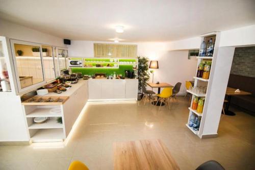 a large kitchen with white cabinets and a table at Casa Boca in Cluj-Napoca