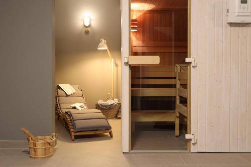 Zimmer mit Stuhl, Lampe und Spiegel in der Unterkunft Villa am Park in Binz