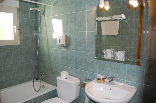 a bathroom with a toilet and a sink and a shower at Hotel Los Duques in Béjar