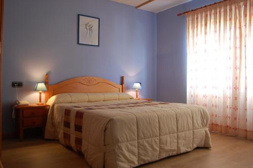 a blue bedroom with a bed and a window at Hotel Los Duques in Béjar