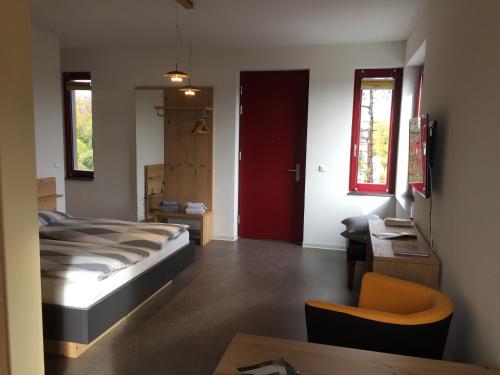 een slaapkamer met een bed en een rode deur bij Appartements am Bauhaus in Dessau