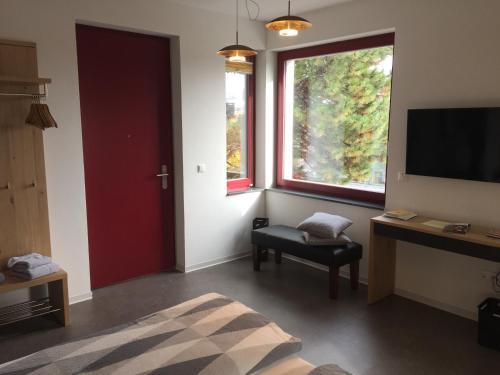 a room with a television and a chair and a window at Appartements am Bauhaus in Dessau