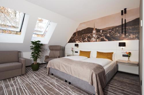 Schlafzimmer mit einem Kingsize-Bett und einem Stuhl in der Unterkunft Boutiquehotel am Stadtgarten in Freiburg im Breisgau
