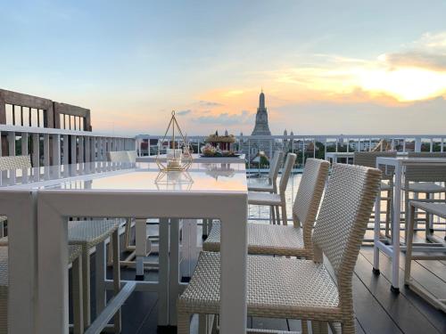 a table and chairs on a balcony with a view of the city at ARUN Riverside Bangkok in Bangkok