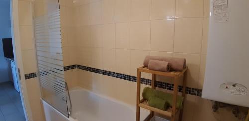 シオーフォクにあるRiviéra Wellness Apartmanのバスルーム(バスタブ、シャワー、タオル付)