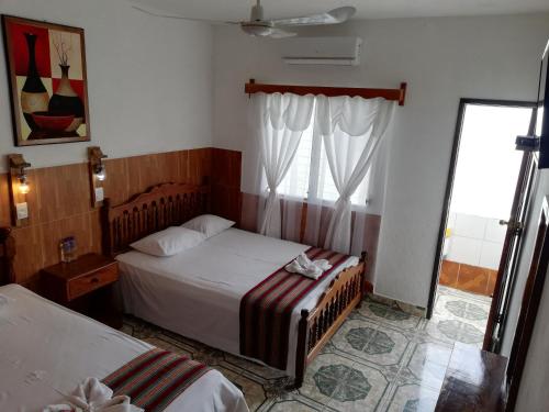 a bedroom with two beds and a window at Hotel La Union in Flores