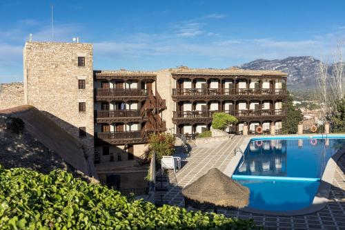 a hotel with a swimming pool in front of a building at Parador de Tortosa in Tortosa