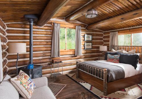 1 dormitorio con 1 cama y chimenea en una cabaña de madera en Lone Mountain Ranch en Big Sky