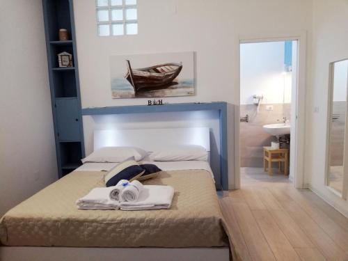 een slaapkamer met 2 bedden en een badkamer met een wastafel bij AlbaChiara B&B in Gaeta