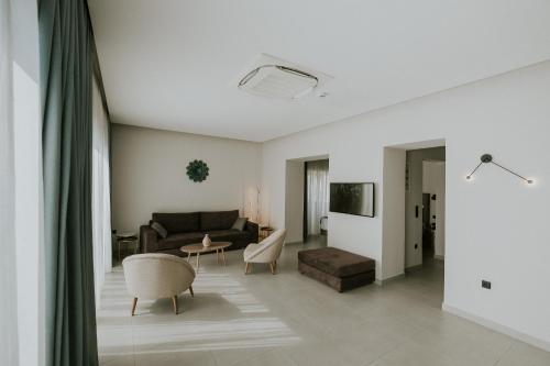 a living room with a couch and a table at Pefkaki Boutique Hotel Loutraki in Loutraki