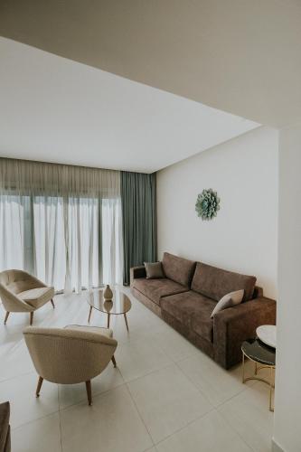a living room with a brown couch and chairs at Pefkaki Boutique Hotel Loutraki in Loutraki