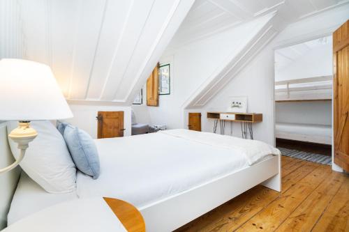 ein weißes Schlafzimmer mit 2 Betten und einer Lampe in der Unterkunft WHome | Sé Skyline Apartment in Lissabon