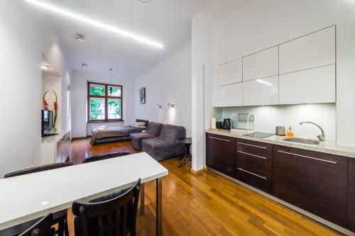 cocina y sala de estar con sofá y mesa en Sewa Apartments, en Cracovia