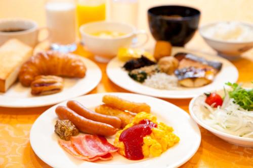 Una mesa con platos de comida para el desayuno. en Kijima Kogen Hotel, en Beppu