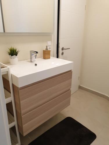 La salle de bains est pourvue d'un lavabo blanc et d'un miroir. dans l'établissement Kleine gemütliche Unterkunft in der Nähe von Köln und Aachen, à Düren