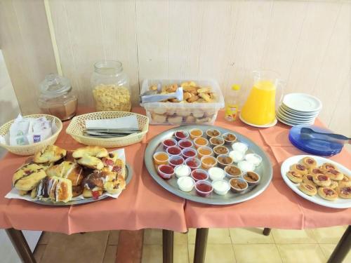 una mesa con platos de comida en una mesa rosa en Hotel Avellino, en Mar del Plata