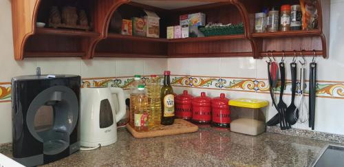 a kitchen counter with a microwave and some bottles and utensils at Villa Quinta da Violeta in Loulé