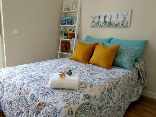 um quarto com uma cama com almofadas coloridas em El Cedro Llorón em Ávila