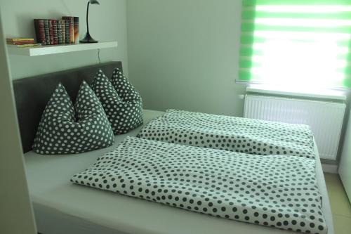 a bed with polka dot pillows on it at Ferienoase Kleine Perle in Pirna