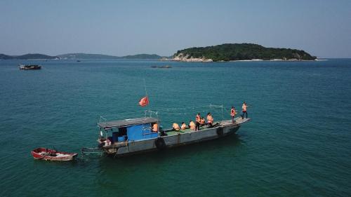 a group of people on a boat in the water at Coto Center Homestay in Dao Co To