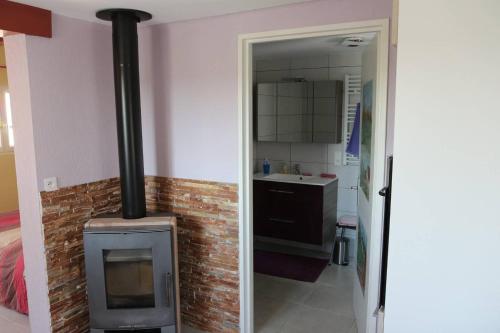 una cocina con estufa de leña en una habitación en Gîte chez Claude & Jacqueline, en Neuwiller-lès-Saverne