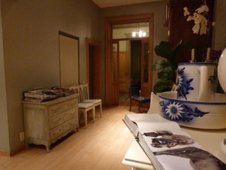 uma sala de estar com uma mesa com um vaso em B&B Sparrow's Nest em Gante