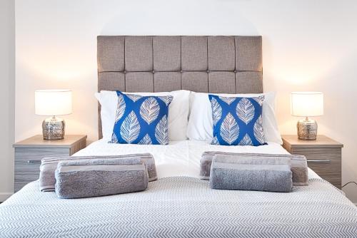 a bedroom with a large bed with blue and white pillows at Spacious 3BR Home with Parking in Swansea in Swansea