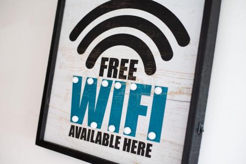 a sign that says free wifi on a wall at Spacious 3BR Home with Parking in Swansea in Swansea