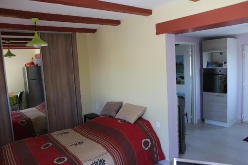 1 dormitorio con 1 cama con manta roja en Gîte chez Claude & Jacqueline, en Neuwiller-lès-Saverne
