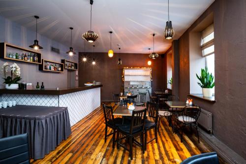 a restaurant with tables and chairs and a bar at Primo Hotel in Rīga