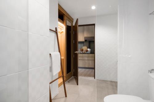 a bathroom with white walls and a toilet and a sink at Reiz - Private Residence in Chiang Mai