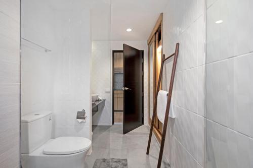a bathroom with a white toilet and a black door at Reiz - Private Residence in Chiang Mai