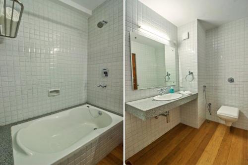 a bathroom with a tub and a sink and a toilet at Prazeres Boutique Hotel in Panaji