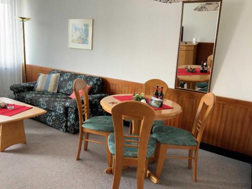 sala de estar con mesa, sillas y sofá en App_ an der Seepromenade _ Mittels, en Malente