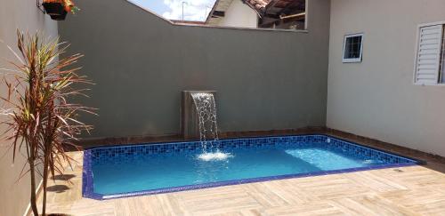 uma piscina com uma fonte de água num quarto em Casa Melo 6 em Olímpia