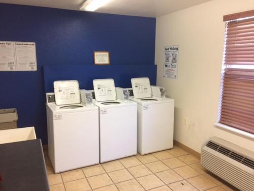 three washing machines in a room with a blue wall at InTown Suites Extended Stay Bowling Green KY in Bowling Green
