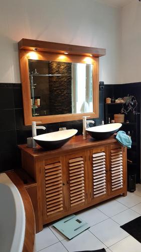 un bagno con due lavandini e uno specchio di Comme à la maison a Le Mans