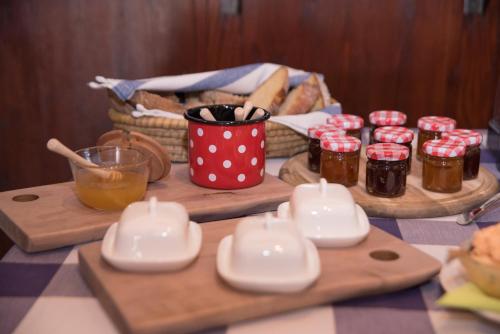 a table with jars of jam and a basket of bread at Bed & Breakfast Dvorec in Petrovče