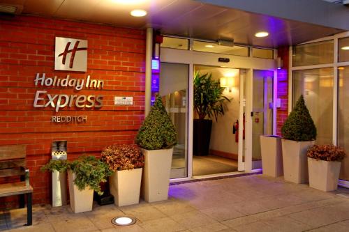a store front with potted plants in front of it at Holiday Inn Express Birmingham Redditch by IHG in Redditch