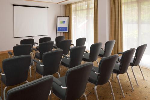 a conference room with chairs and a screen at Holiday Inn Express Birmingham Redditch by IHG in Redditch