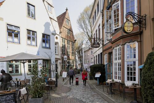 a street with buildings and people walking down a street at Holiday Inn Express Bremen Airport by IHG in Bremen